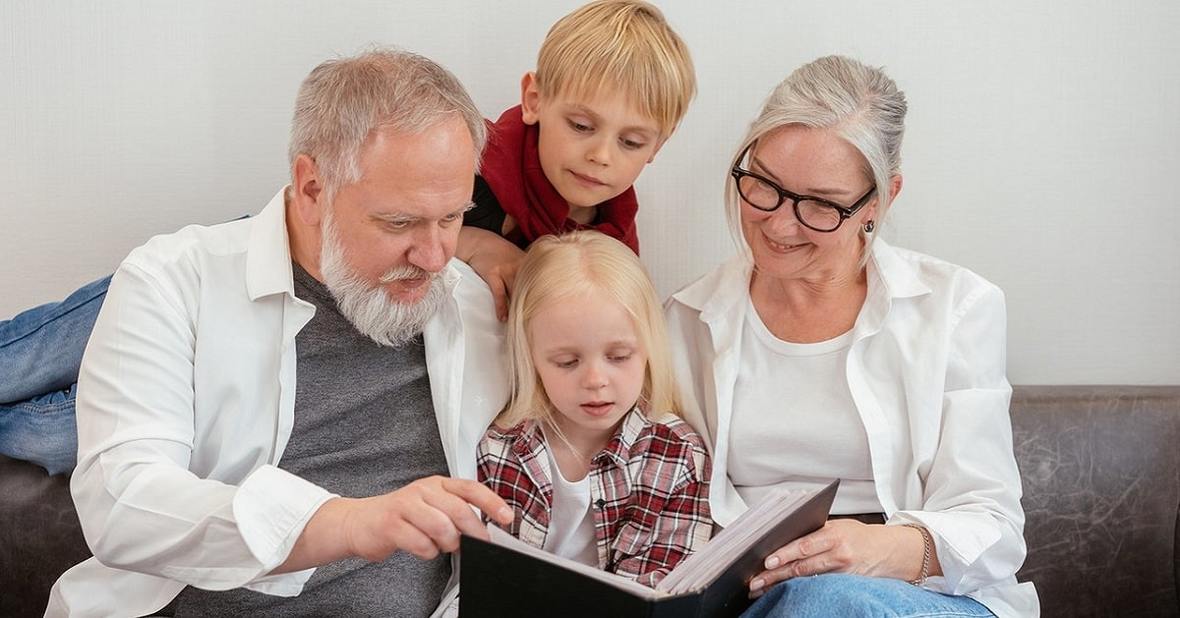 Abuelos leyendo un cuento con sus dos nietos