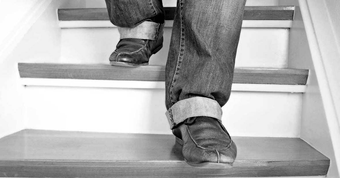 Persona mayor a la que solo se le ven las piernas bajando por las escaleras, una situación que supone un riesgo de caída en ancianos