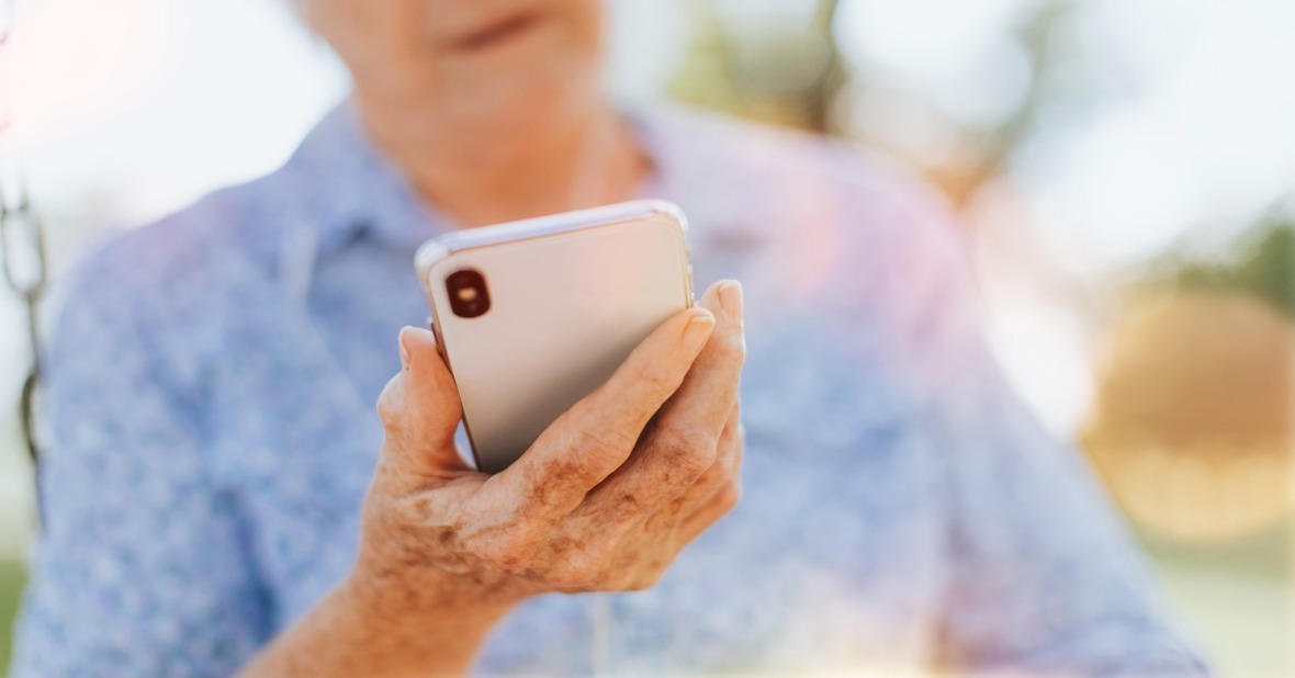 Mujer mayor utilizando su teléfono para enviar mensajes a sus familiares