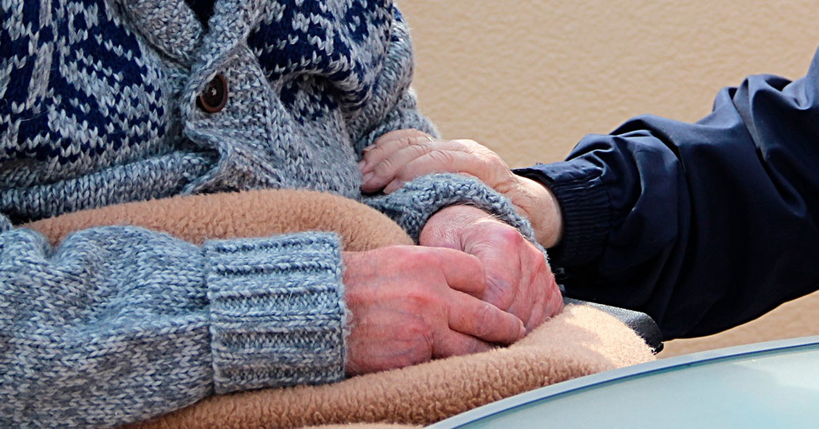 Persona mayor sentada al lado de un familiar, quienes más sufren el síndrome del cuidador