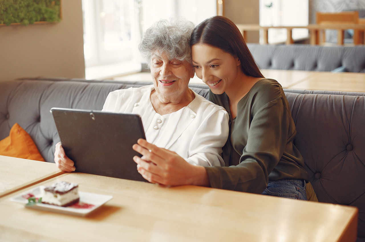 Mujer mayor mirando tablet junto a su nieta