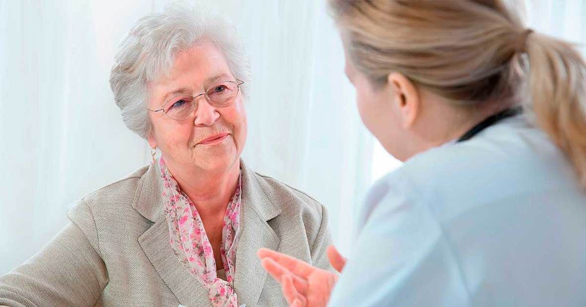 Doctor recomendando a una persona mayor sobre cómo tomar las pastillas que le ha recetado
