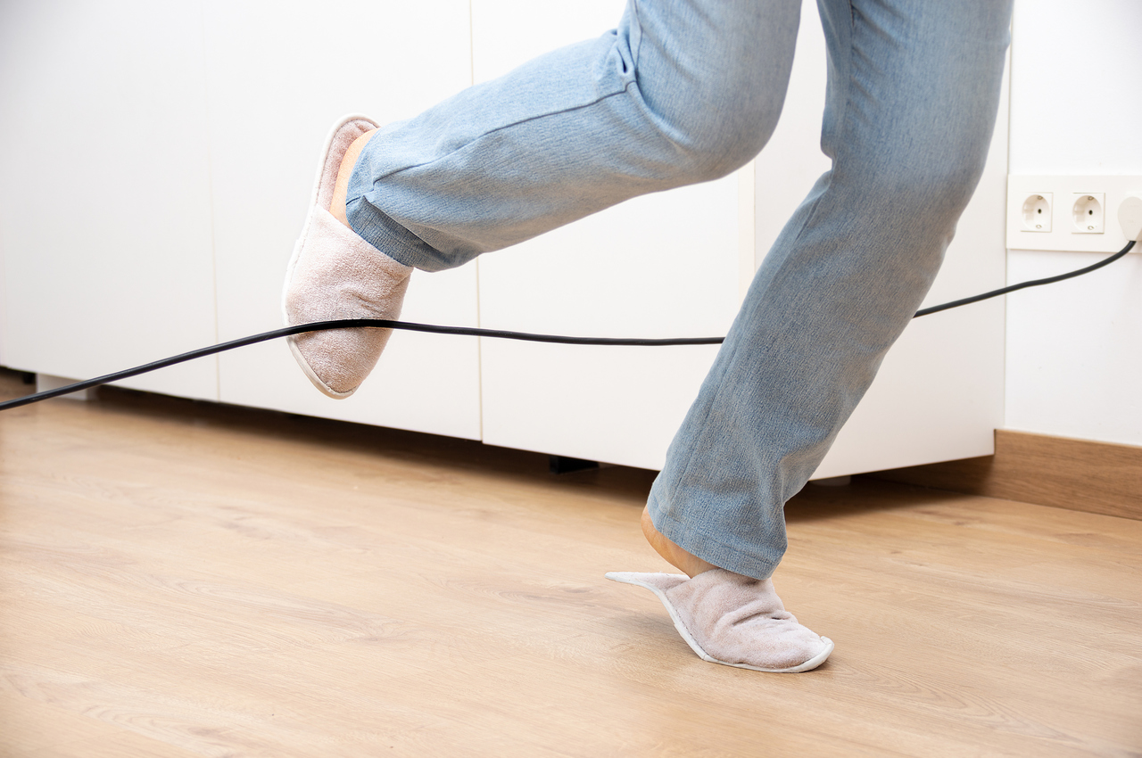 Una persona a punto de caerse tras tropezarse con un cable extendido.