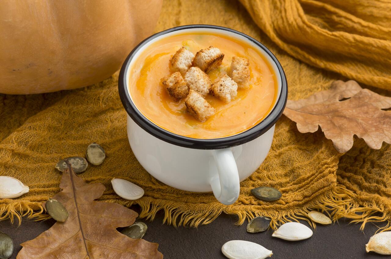 Un puré de calabaza con picatostes servido en una taza grande.
