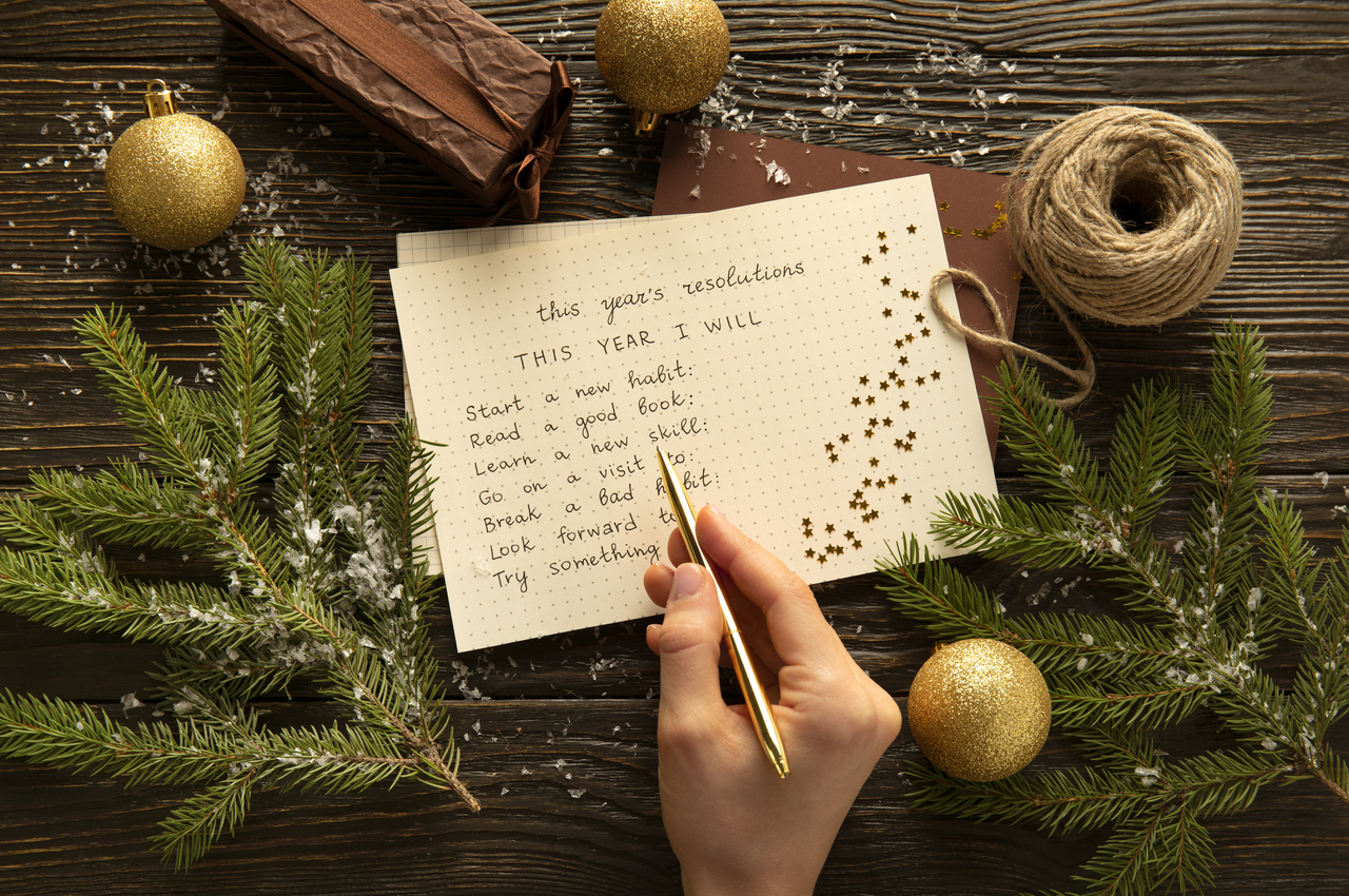 Una persona anota sus propósitos de año nuevo en una hoja.