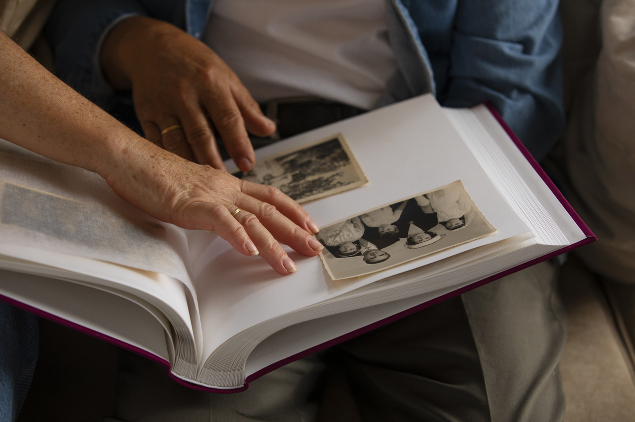 Dos personas mayores miran un álbum de fotos antiguas