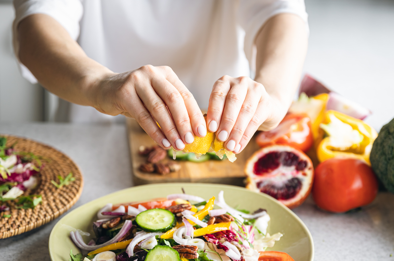 Una persona prepara una ensalada variada.