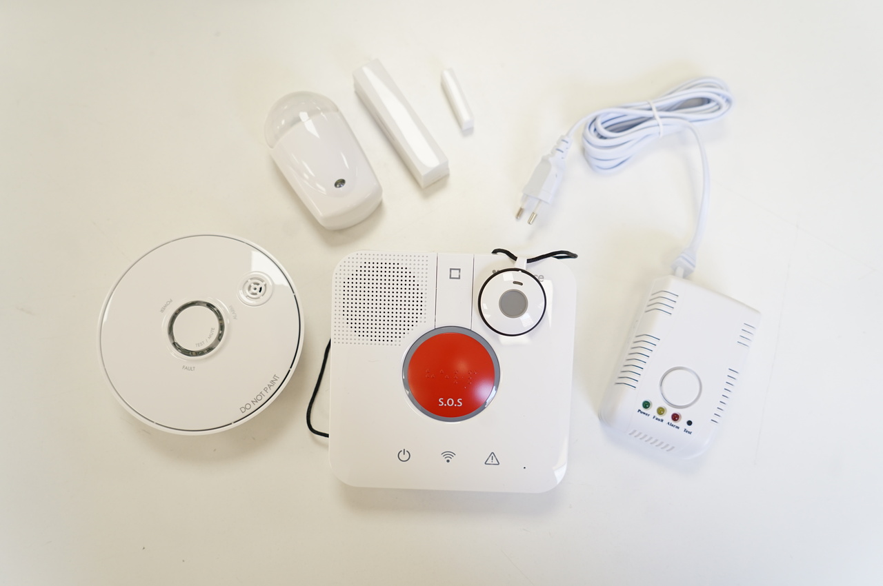 Diversos dispositivos de teleasistencia avanzada: detector de humo, de movimiento, de gas y un pulsador SOS fijo y otro de control remoto.