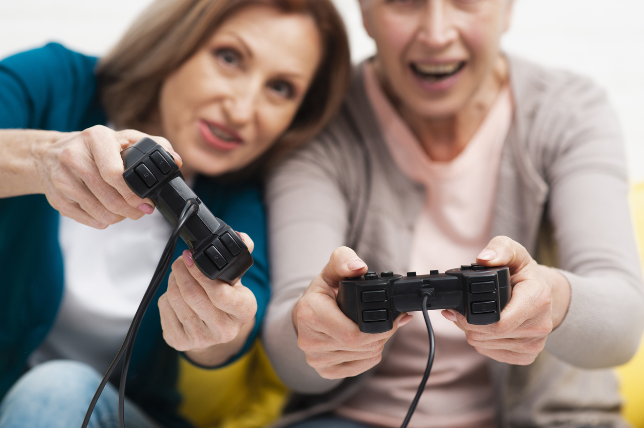 Dos mujeres mayores juegan a videojuegos y pasan un buen rato.
