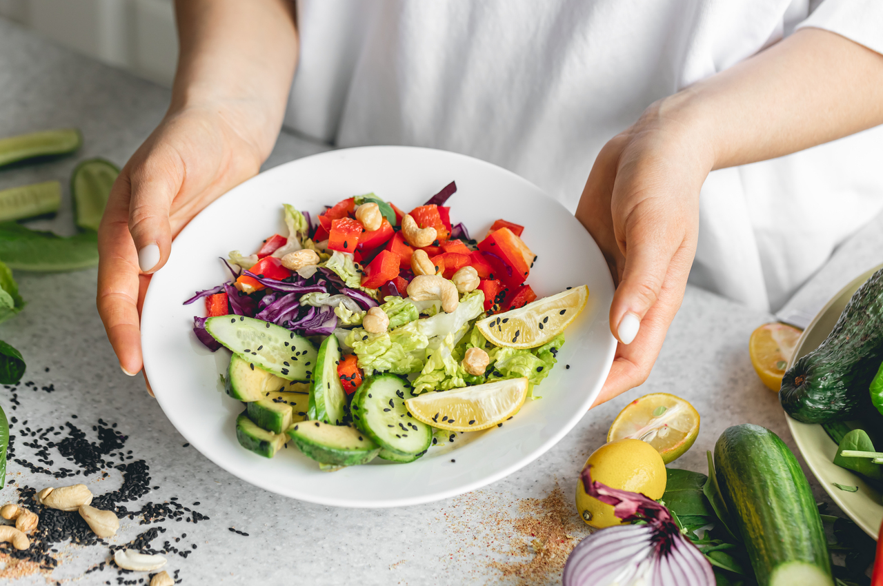 Una ensalada con pimiento, pepino, limón, remolacha y anacardos.