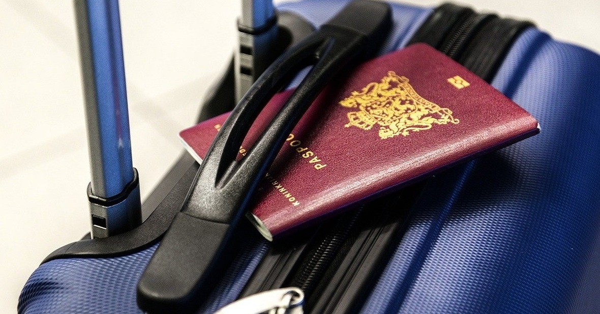 Maleta azul con un pasaporte encima, un documento necesario para viajar al extranjero