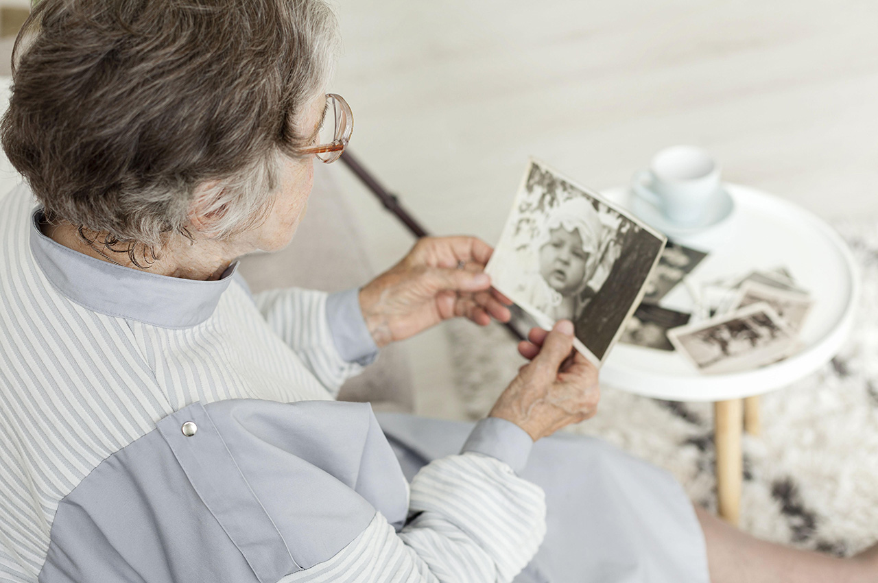Mujer mayor mirando una foto antigua.