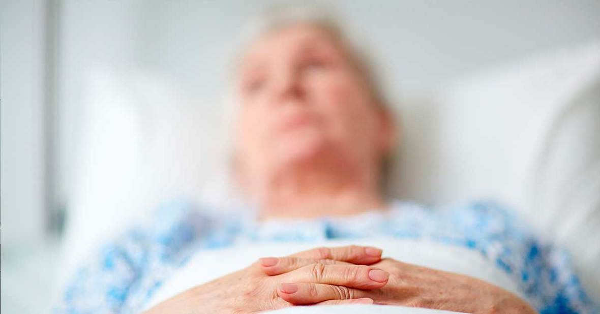 Mujer mayor tumbada en la cama que necesita usar pañal porque sufre de demencia