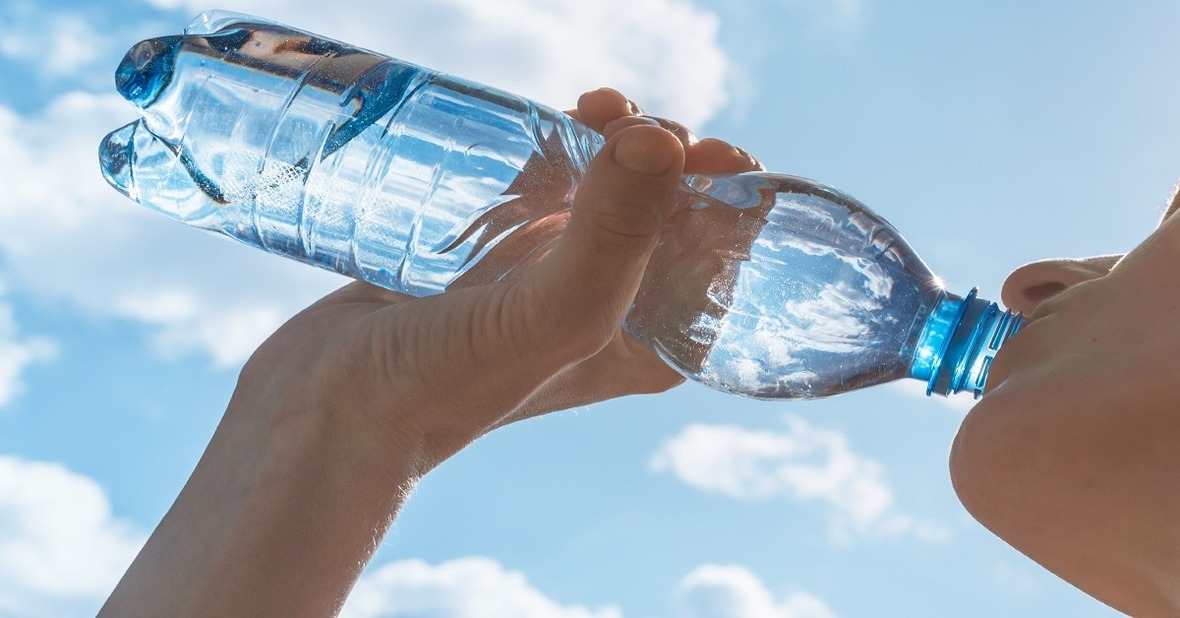 Mujer bebiendo una botella de agua en verano para recuperar líquidos y evitar una deshidratación
