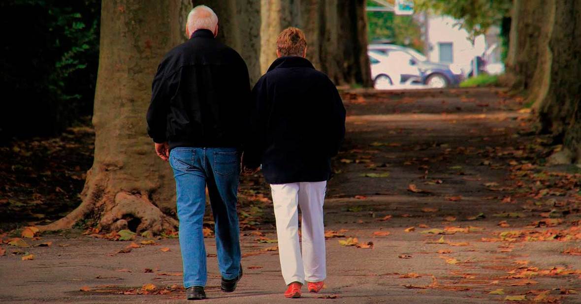 Personas mayores paseando por un parque para curar el estreñimiento