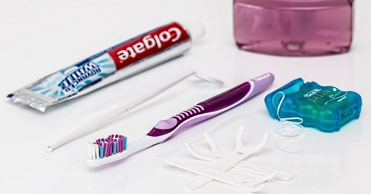 Foto de un cepillo de dientes, pasta e hilo dental y otros elementos de higiene bucal, fundamentales para una rutina de aseo en personas mayores