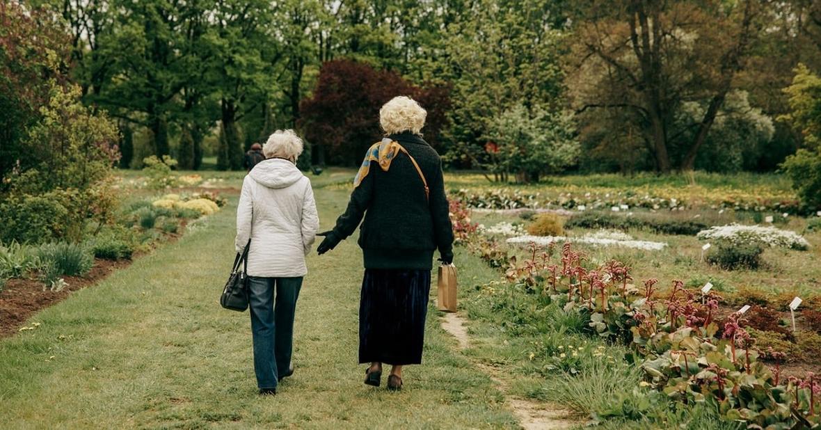 Dos mujeres mayores hablando y paseando por un parque