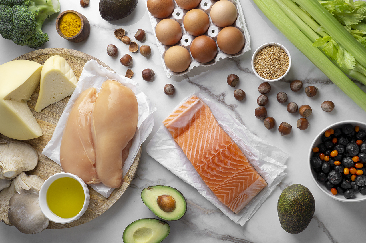 Bodegón de alimentos beneficiosos para la piel: pollo, salmón o huevos.