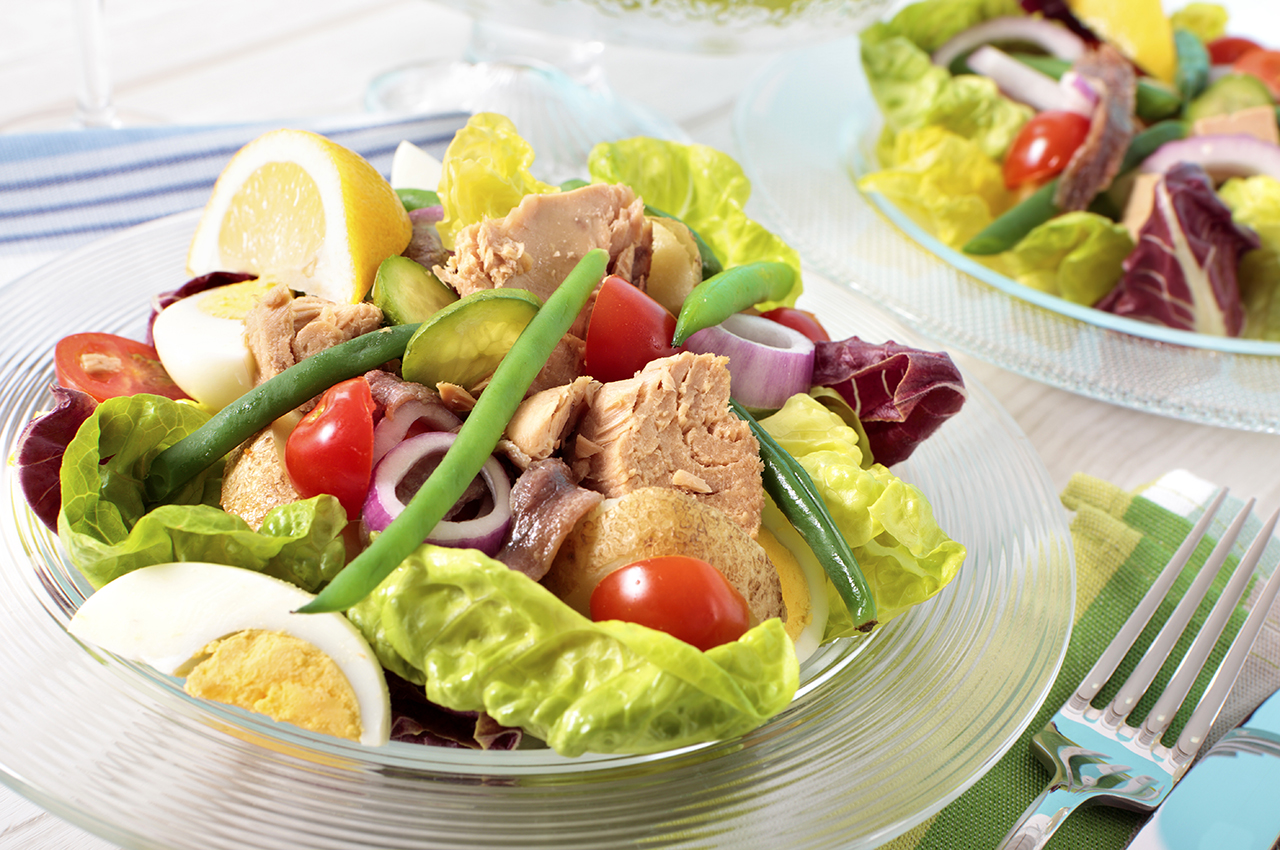 Una ensalada completa con huevo, lechuga, atún, tomate, cebolla.