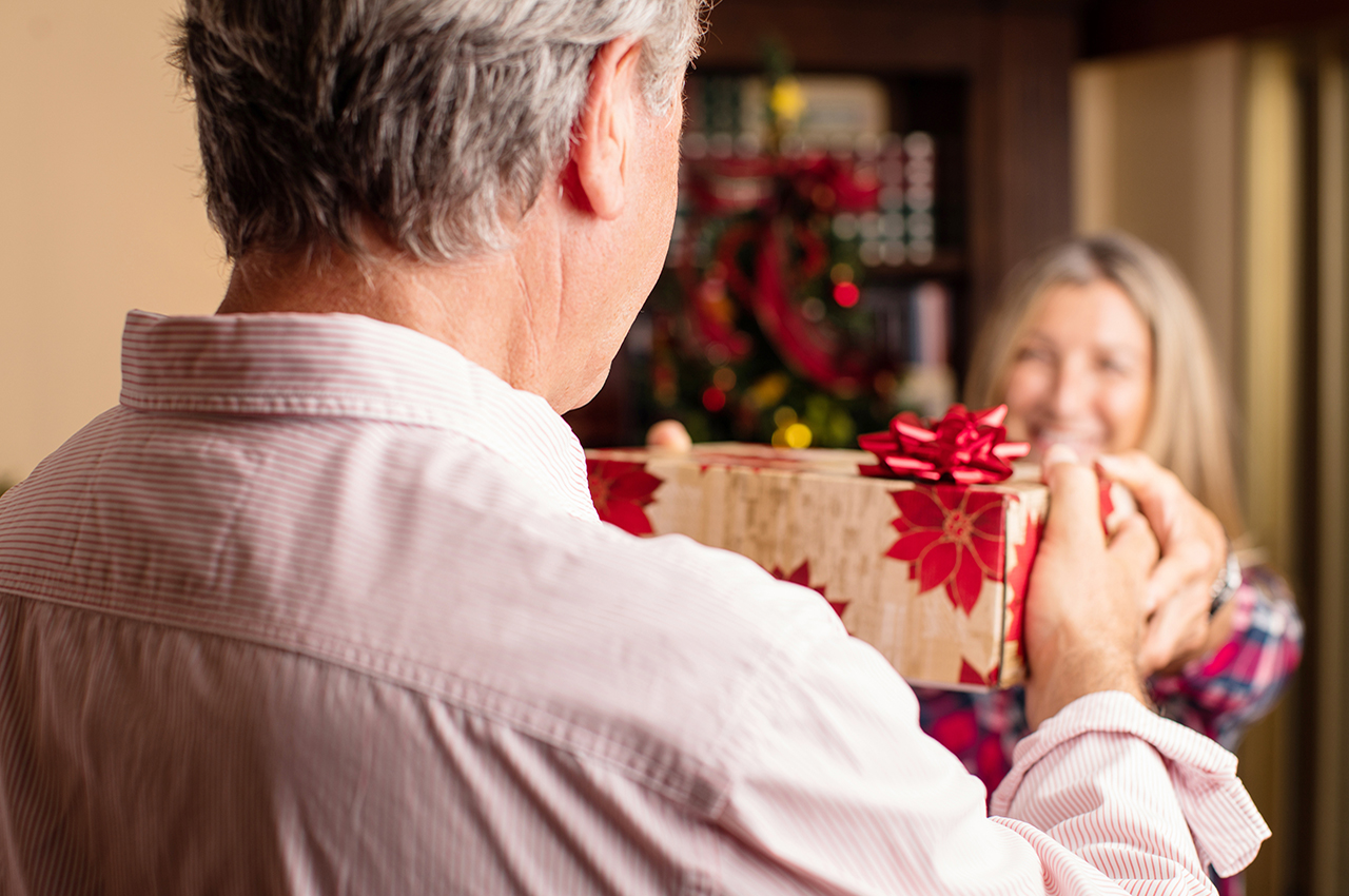 Un hombre mayor recibe un regalo de Navidad.